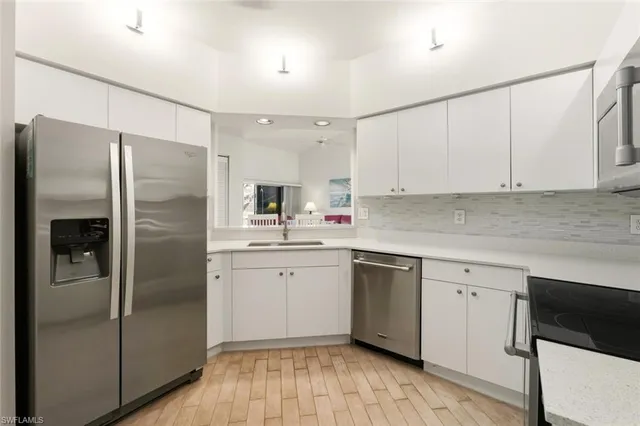 a kitchen with a refrigerator a sink and cabinets