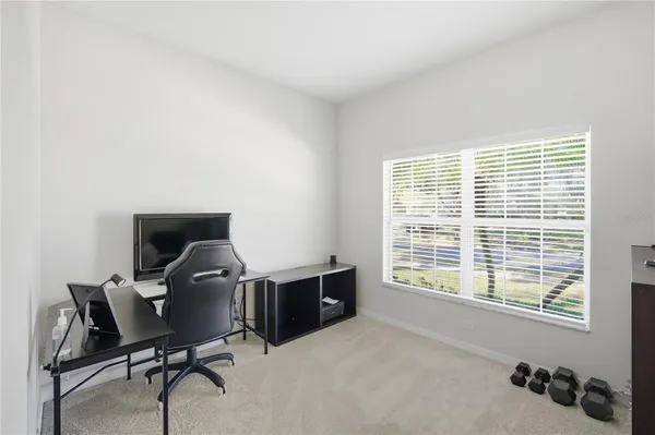 a view of a workspace with furniture and a window