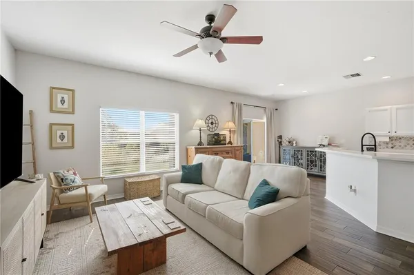 a living room with furniture and a large window with wooden floor