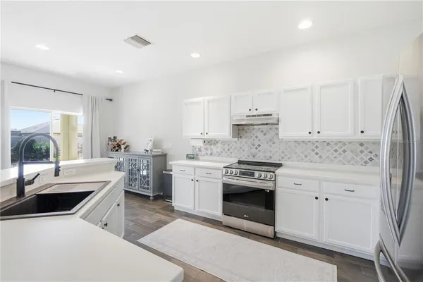 a kitchen with white cabinets and white appliances