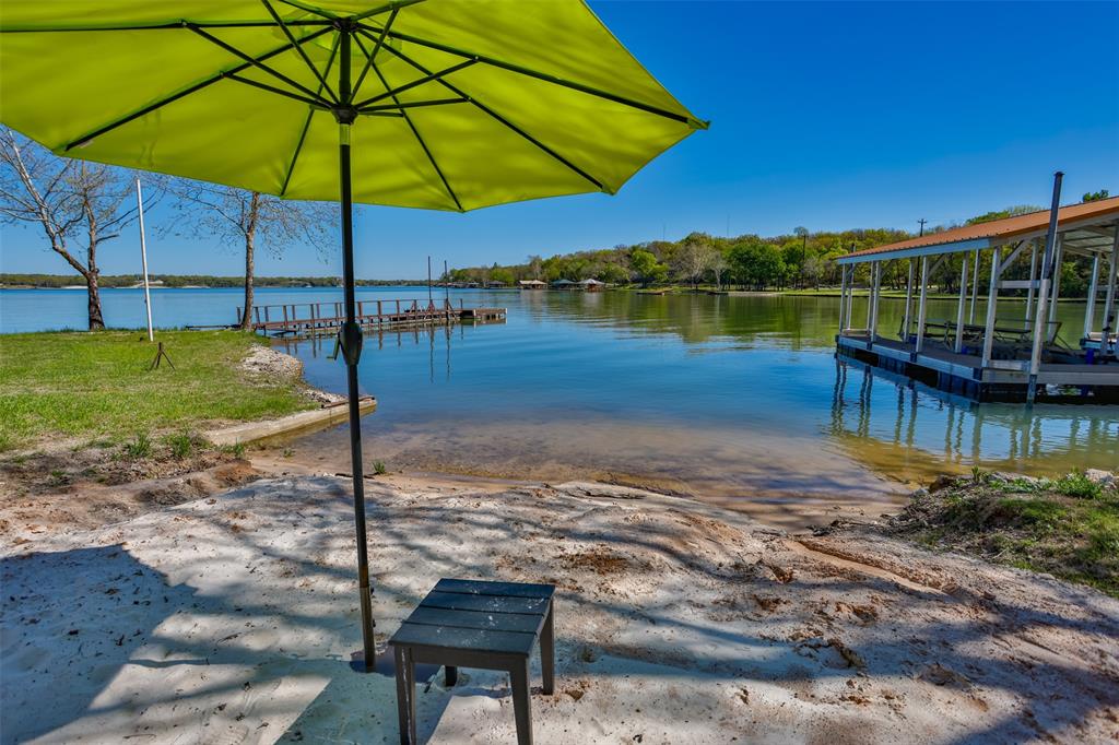 a view of a lake with a table and chairs under an umbrella