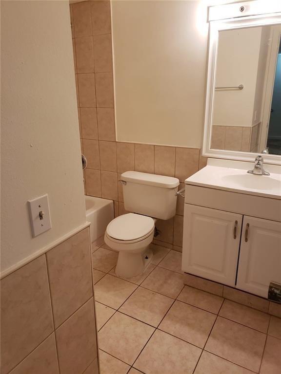 1850 West 72nd Place, Unit 1850 Hialeah, FL 33014 - Photo 6 of 8 a bathroom with a toilet a sink and mirror