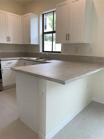 a kitchen with a sink cabinets and window