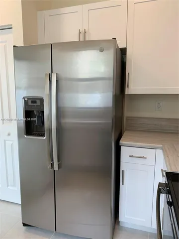 a close view of a refrigerator in kitchen and stainless steel appliances wooden floor