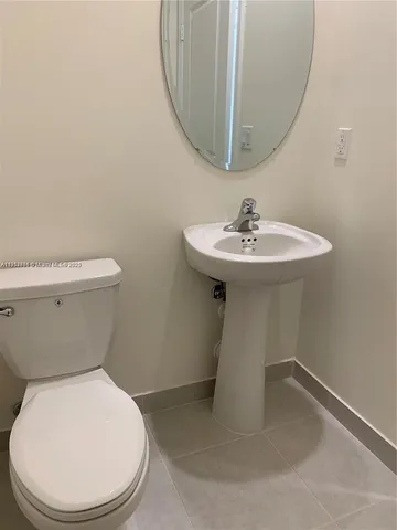 a white toilet sitting next to a bathroom sink
