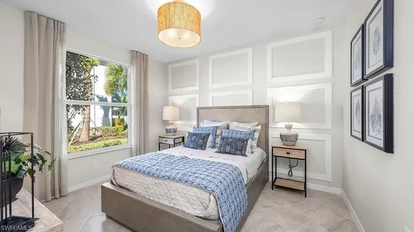 a bedroom with a bed and a window with potted plants