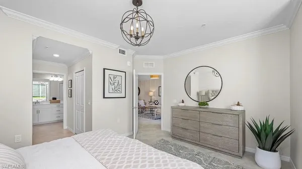 a bedroom with a large bed and a chandelier