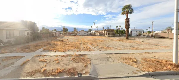 a view of a street with a cars park on the side of road