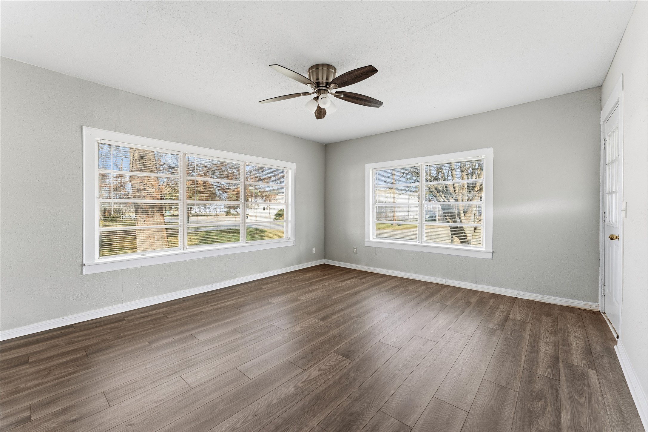 2105 Beaumont Road Baytown, TX 77520 - Photo 7 of 17 a view of an empty room with wooden floor and a window