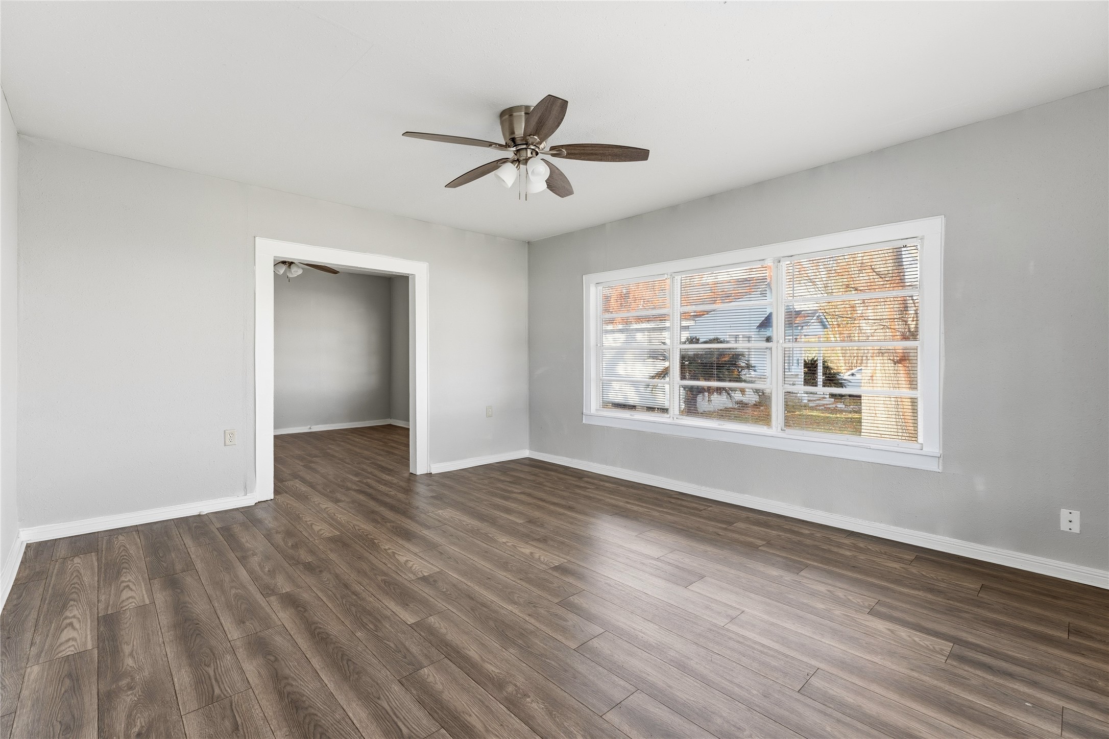 2105 Beaumont Road Baytown, TX 77520 - Photo 9 of 17 a view of an empty room with wooden floor and a window
