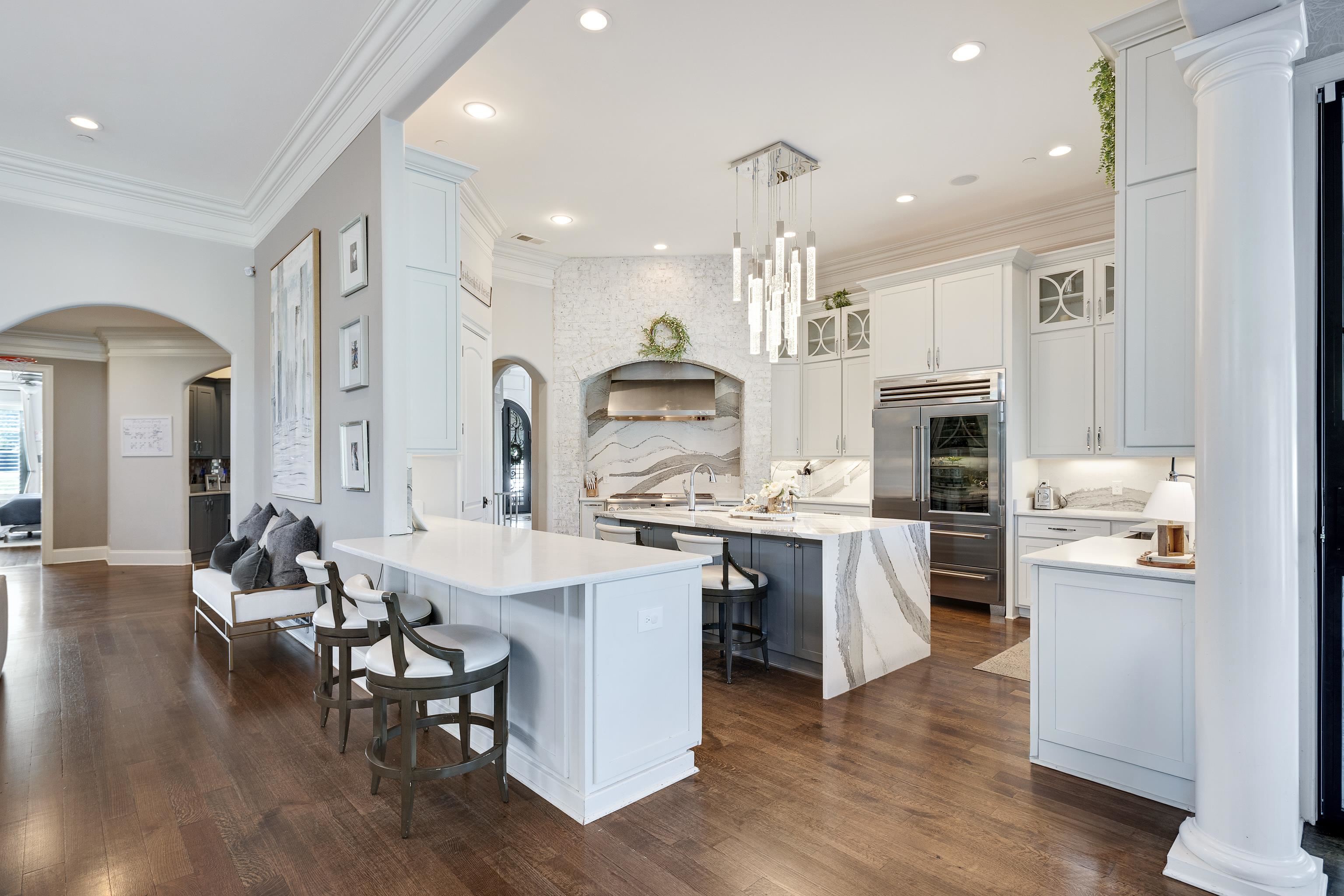 3246 Hollow Creek Road Germantown, TN 38138 - Photo 14 of 40 a kitchen with stainless steel appliances kitchen island granite countertop a stove top oven a sink a refrigerator and white cabinets with wooden floor