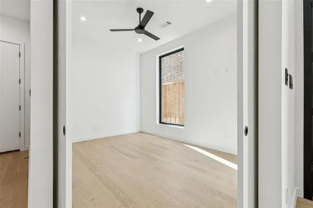 a view of empty room with window and ceiling fan