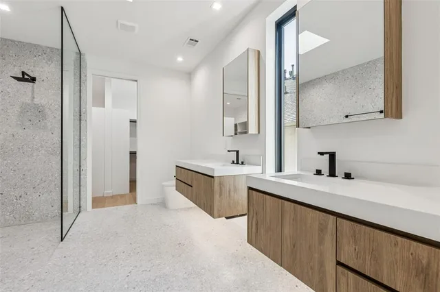a bathroom with a double vanity sink mirror and shower