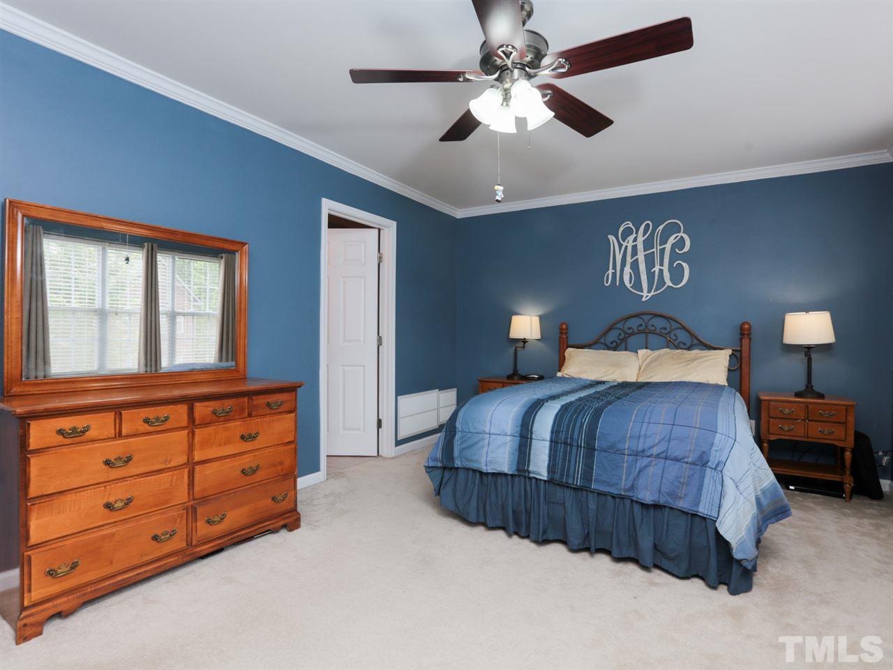 9908 Layla Avenue Raleigh, NC 27617 - Photo 14 of 25 a bedroom with a bed and a chandelier