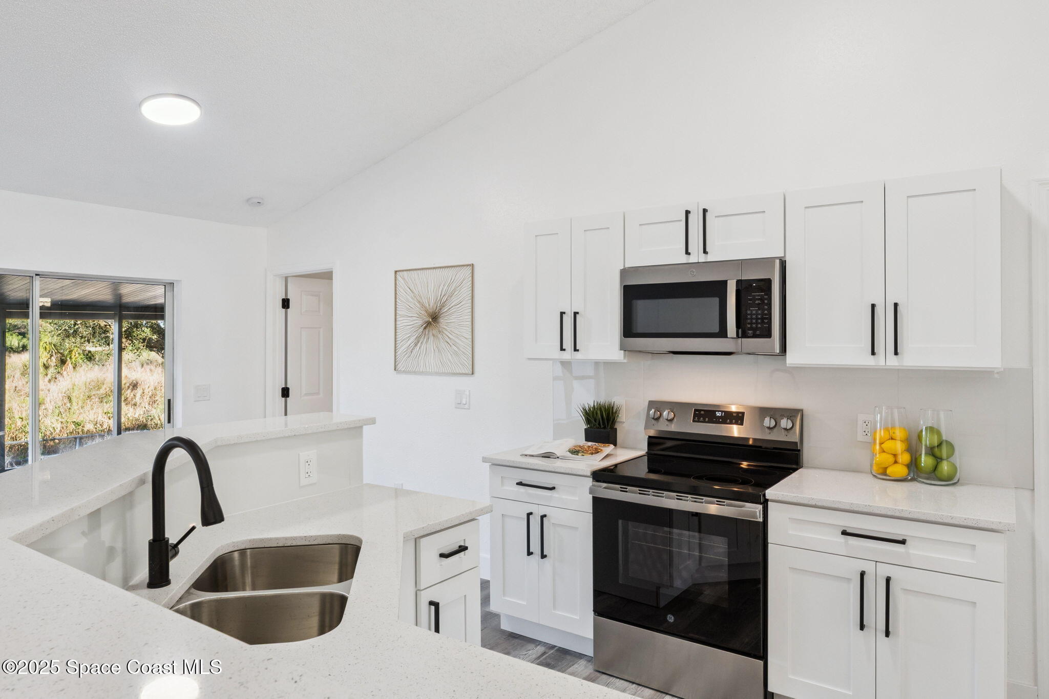 6200 Edison Street Cocoa, FL 32927 - Photo 12 of 21 a kitchen with stainless steel appliances granite countertop a sink a stove a microwave a refrigerator a counter space and cabinets