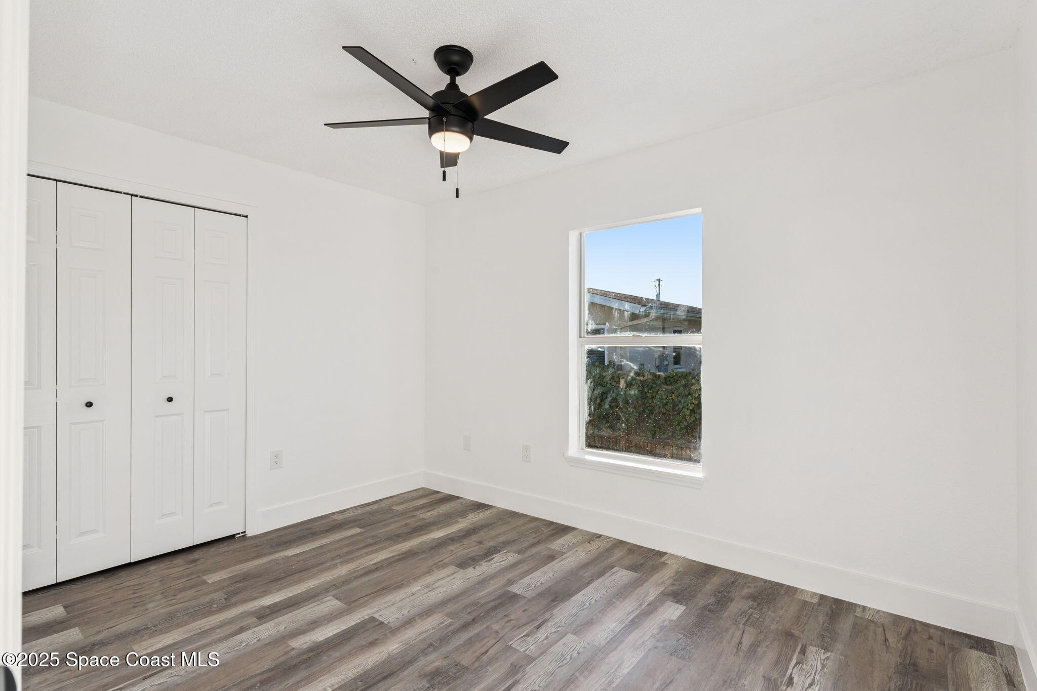 6200 Edison Street Cocoa, FL 32927 - Photo 16 of 21 an empty room with wooden floor ceiling fan and windows