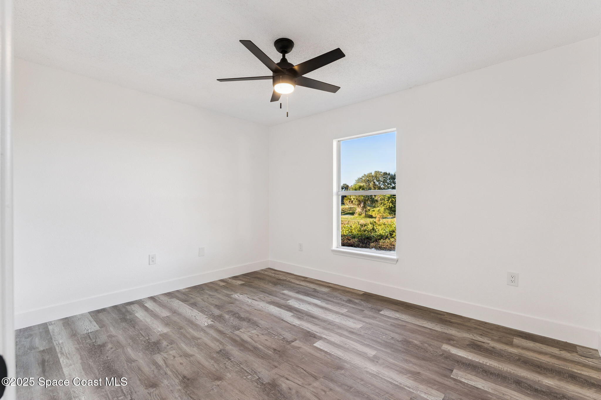 6200 Edison Street Cocoa, FL 32927 - Photo 18 of 21 an empty room with window and ceiling fan