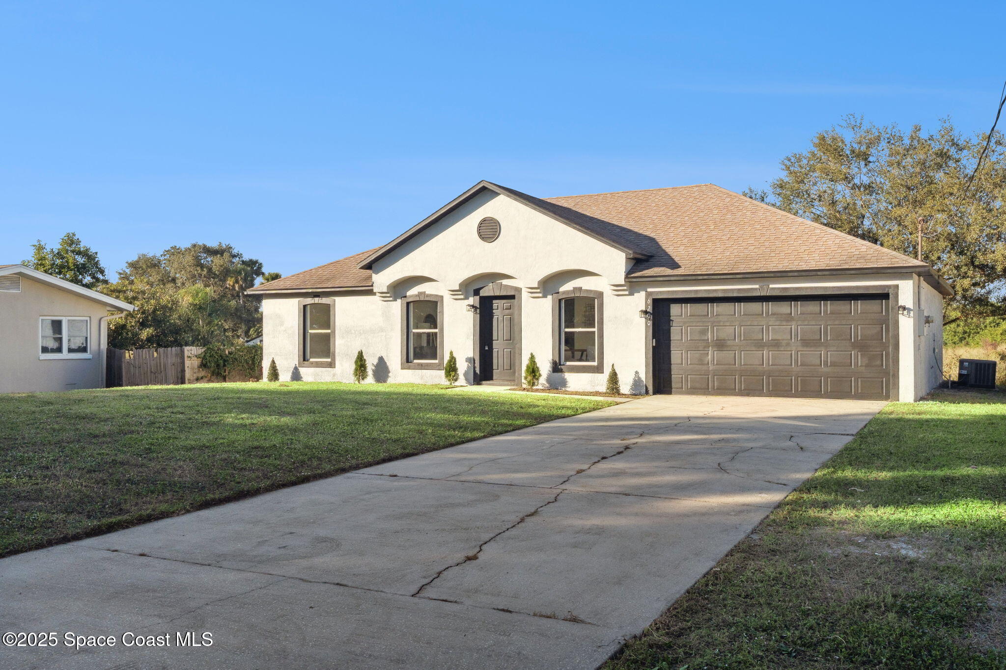 6200 Edison Street Cocoa, FL 32927 - Photo 4 of 21 a view of a white house with a yard and large tree