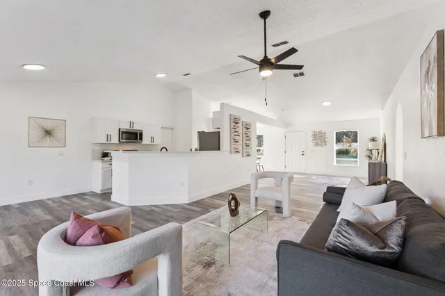 a living room with furniture and kitchen view