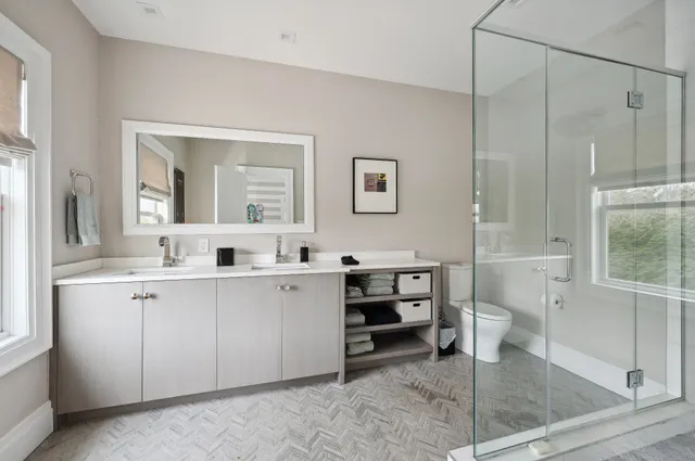 a spacious bathroom with a double vanity sink a mirror and a bathtub