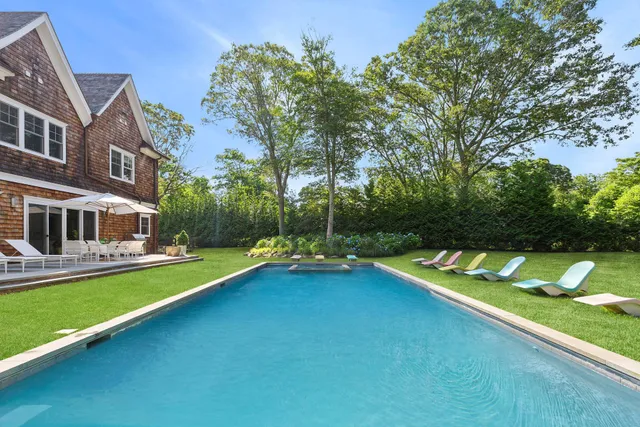 a view of a house with swimming pool and sitting area