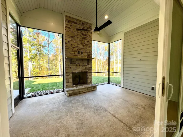 a view of an empty room with a fireplace and a window