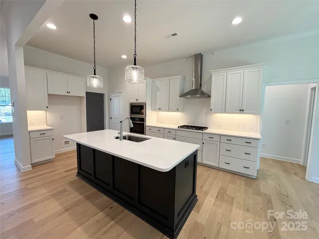 a kitchen that has a lot of cabinets in it with wooden floor