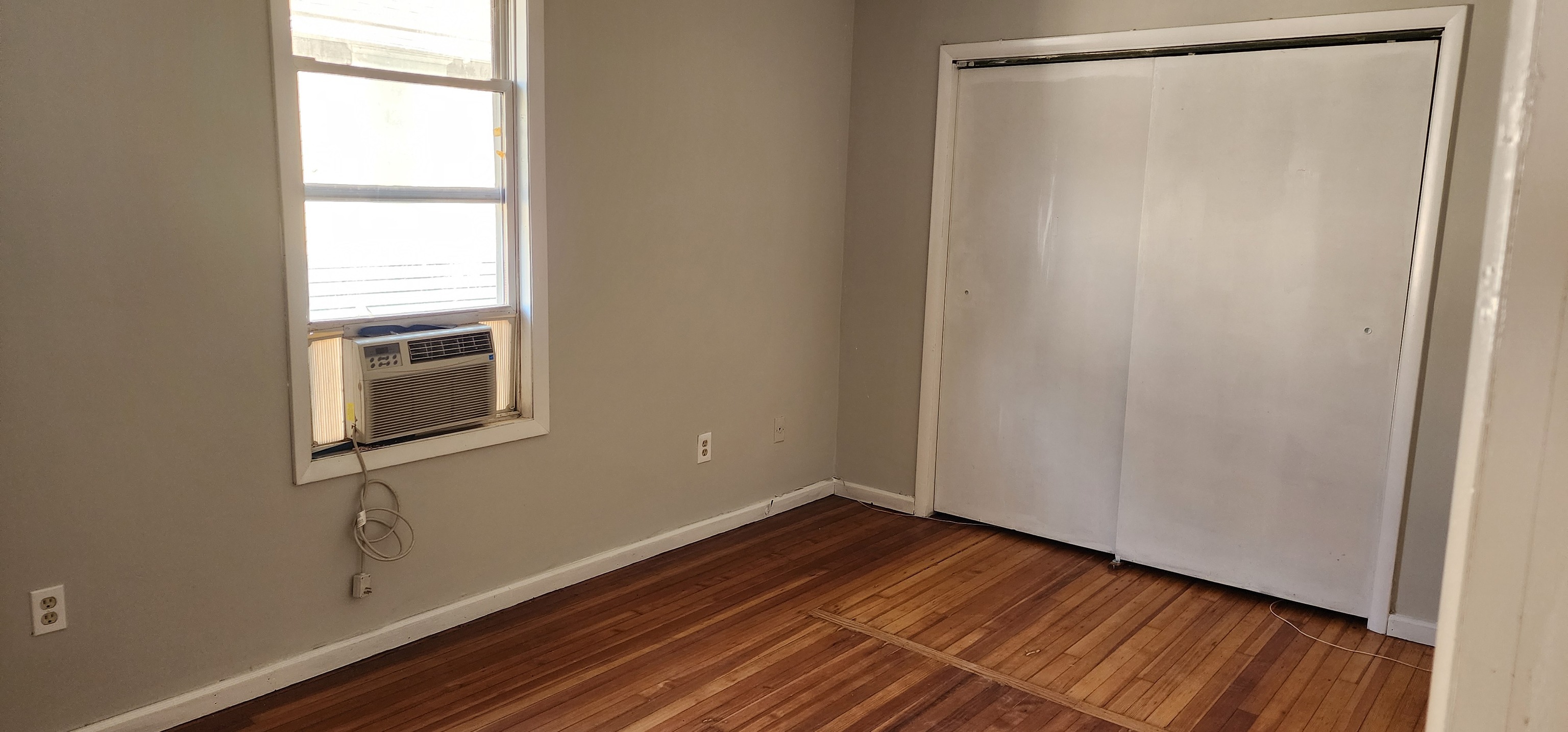 539 Garfield Avenue Bridgeport, CT 06606 - Photo 6 of 7 a view of an empty room with wooden floor and a window
