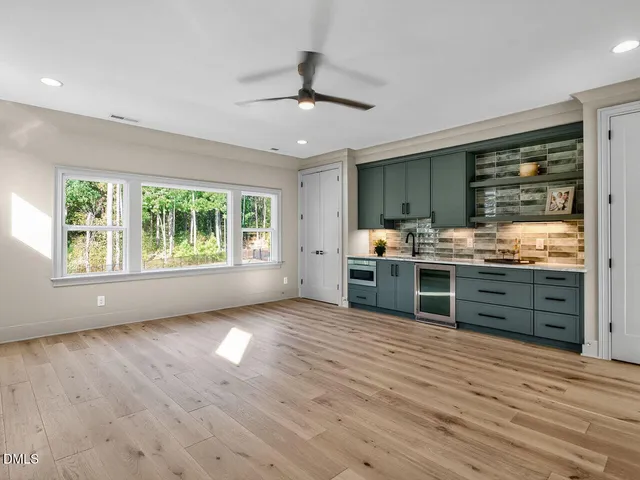 a kitchen with stainless steel appliances wooden floors and view living room