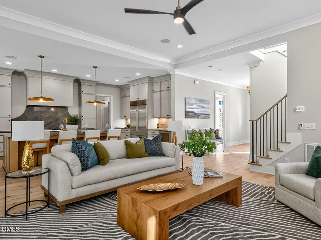 a living room with furniture kitchen view and a potted plant