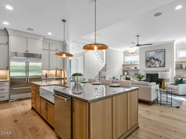 a kitchen with stainless steel appliances granite countertop a sink a stove a refrigerator and island