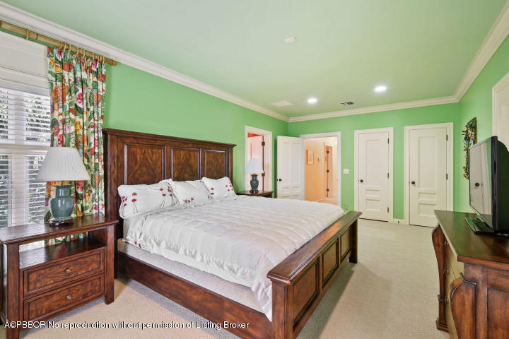 515 South Beach Road Hobe Sound, FL 33455 - Photo 19 of 30 a bedroom with a large bed a flat tv screen and a dresser