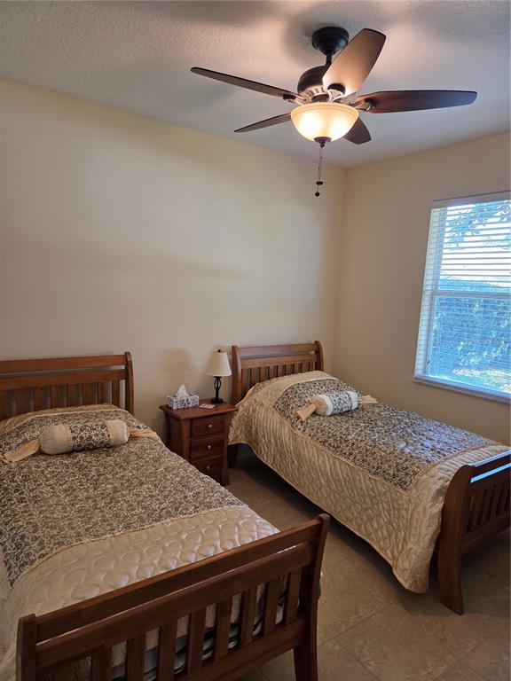 527 Safe Harbor Drive Edgewater, FL 32141 - Photo 18 of 33 a bedroom with two beds and a chandelier