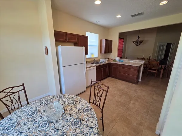a kitchen with a refrigerator and a stove top oven