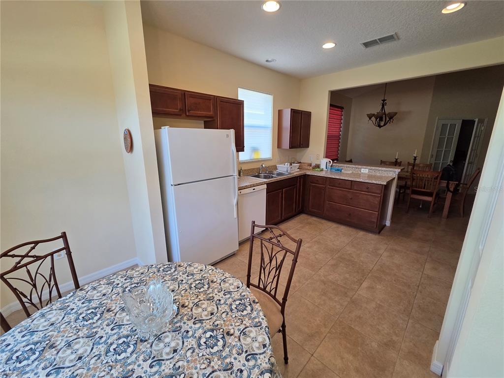 527 Safe Harbor Drive Edgewater, FL 32141 - Photo 8 of 33 a kitchen with a refrigerator and a stove top oven