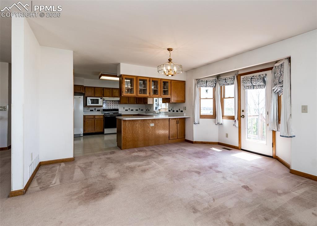 6185 Sayres Road Colorado Springs, CO 80927 - Photo 12 of 50 a view of a kitchen with a sink stove cabinets and empty room