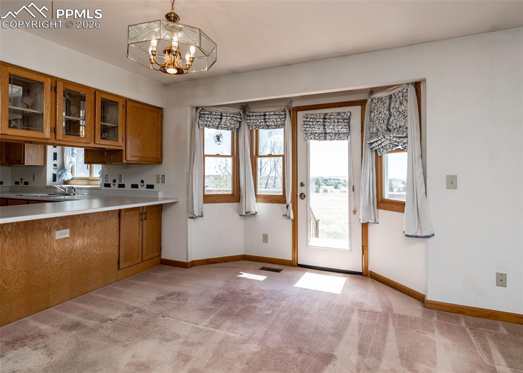 6185 Sayres Road Colorado Springs, CO 80927 - Photo 13 of 50 a view of a kitchen with a sink dishwasher a kitchen with wooden floor and chandelier