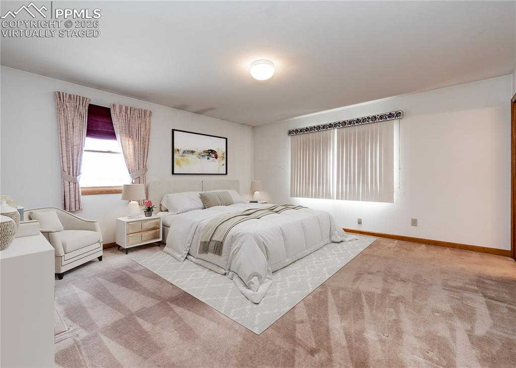 6185 Sayres Road Colorado Springs, CO 80927 - Photo 21 of 50 a spacious bedroom with a bed and a couch