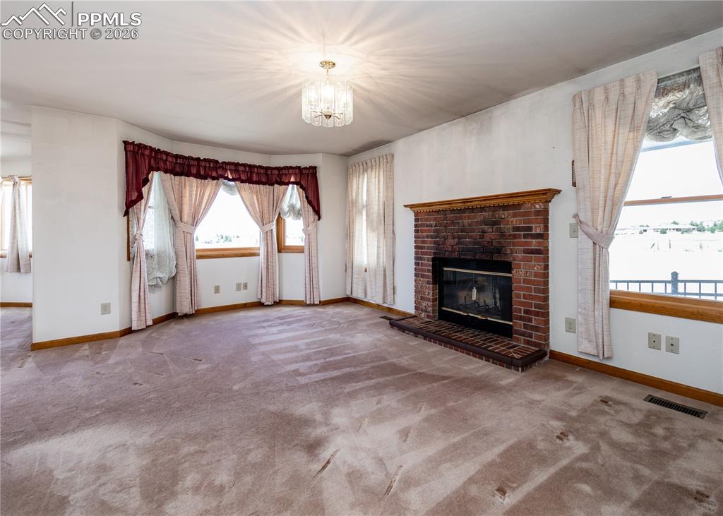 6185 Sayres Road Colorado Springs, CO 80927 - Photo 24 of 50 an empty room with windows and fireplace