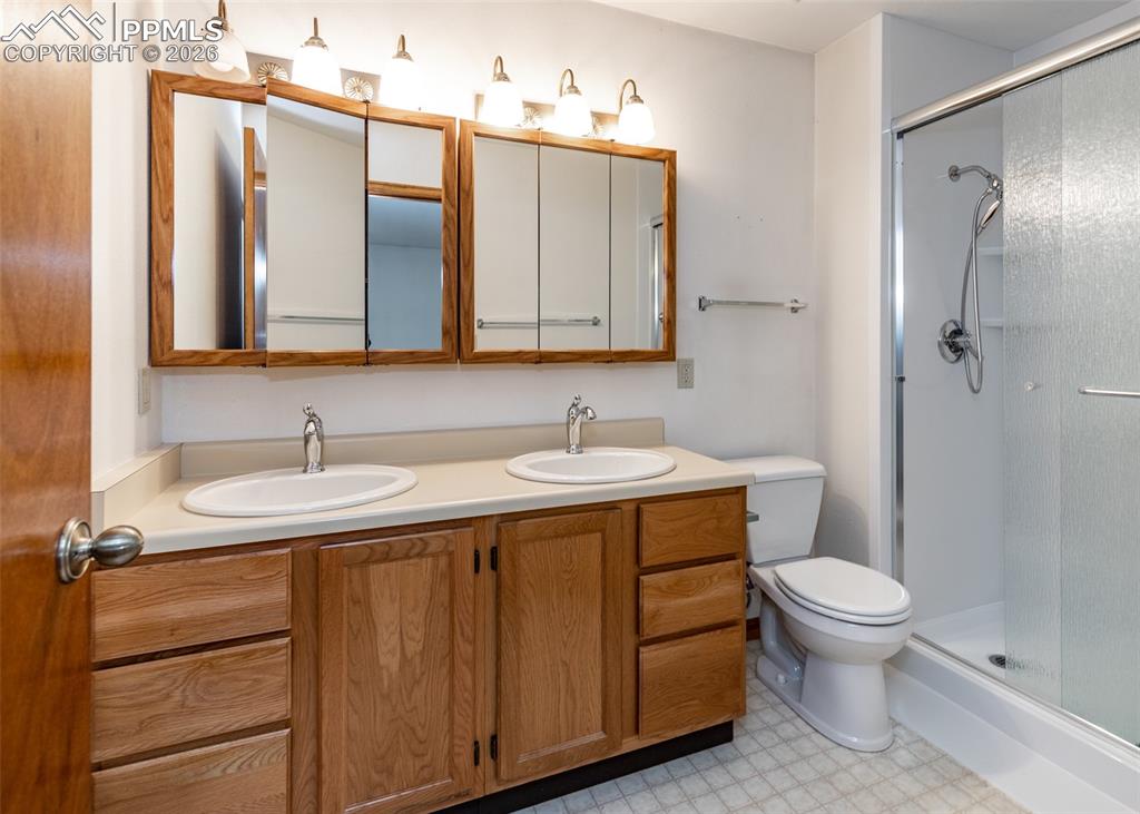 6185 Sayres Road Colorado Springs, CO 80927 - Photo 26 of 50 a bathroom with a granite countertop sink toilet and shower