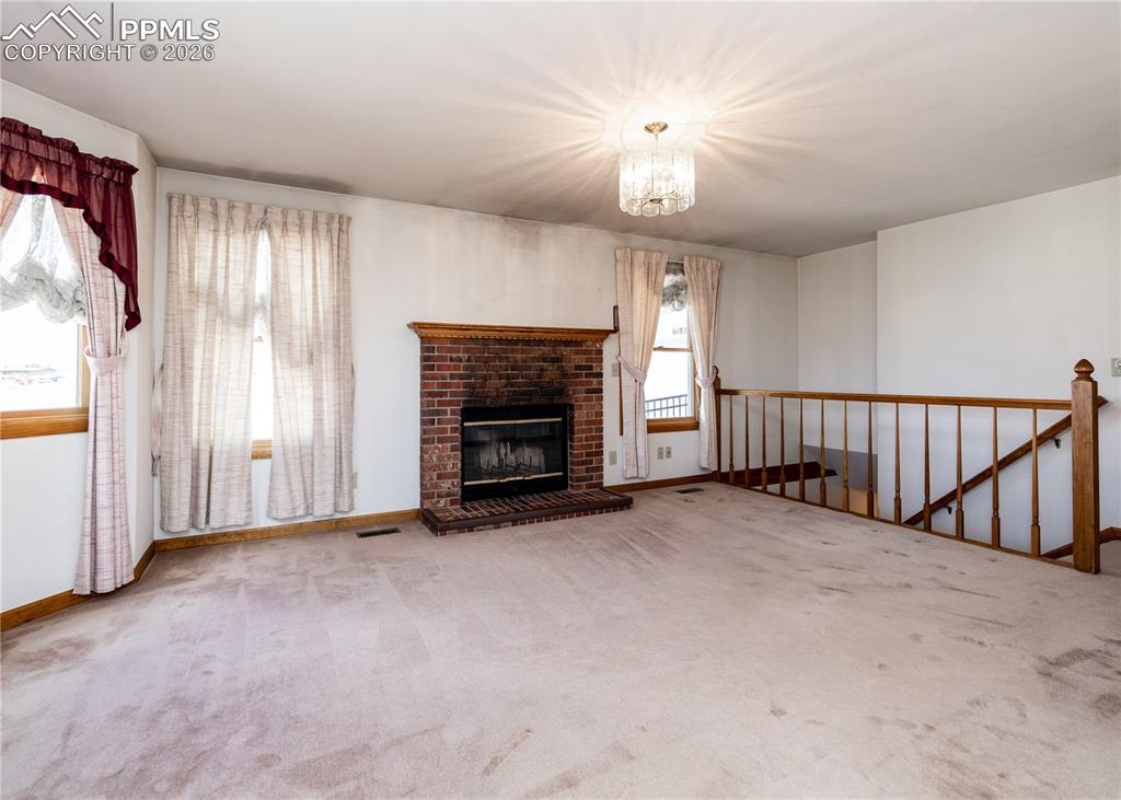 6185 Sayres Road Colorado Springs, CO 80927 - Photo 9 of 50 an empty room with windows and fireplace