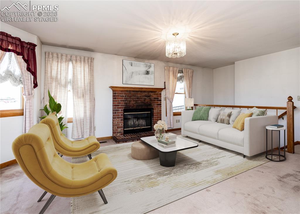6185 Sayres Road Colorado Springs, CO 80927 - Photo 10 of 50 a living room with furniture a fireplace and a chandelier