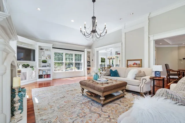 a living room with furniture a fireplace and a chandelier