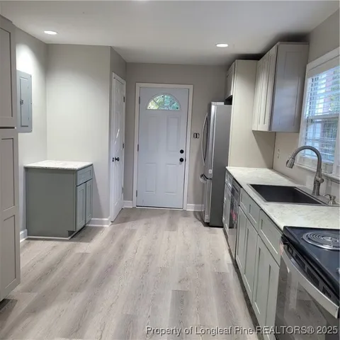 a kitchen with stainless steel appliances granite countertop a sink stove and refrigerator