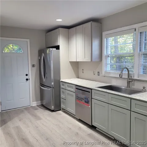a kitchen with stainless steel appliances granite countertop a refrigerator sink and cabinets
