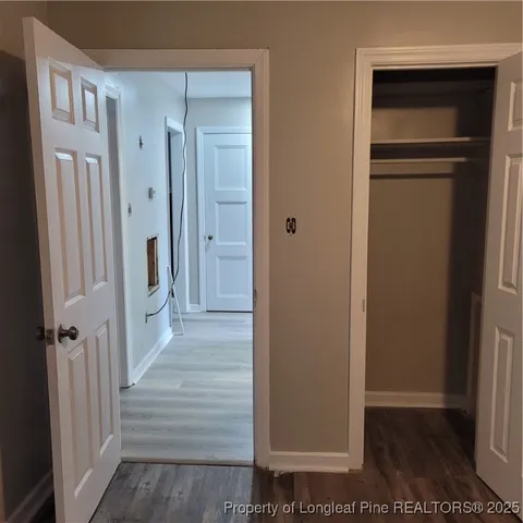 a view of a hallway with wooden floor and closet