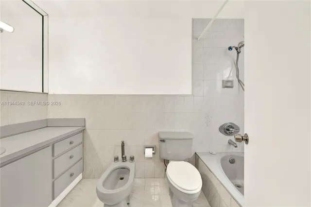a bathroom with a granite countertop toilet sink and mirror
