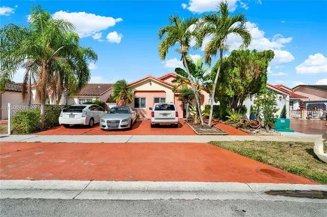 a couple of cars parked in front of a house