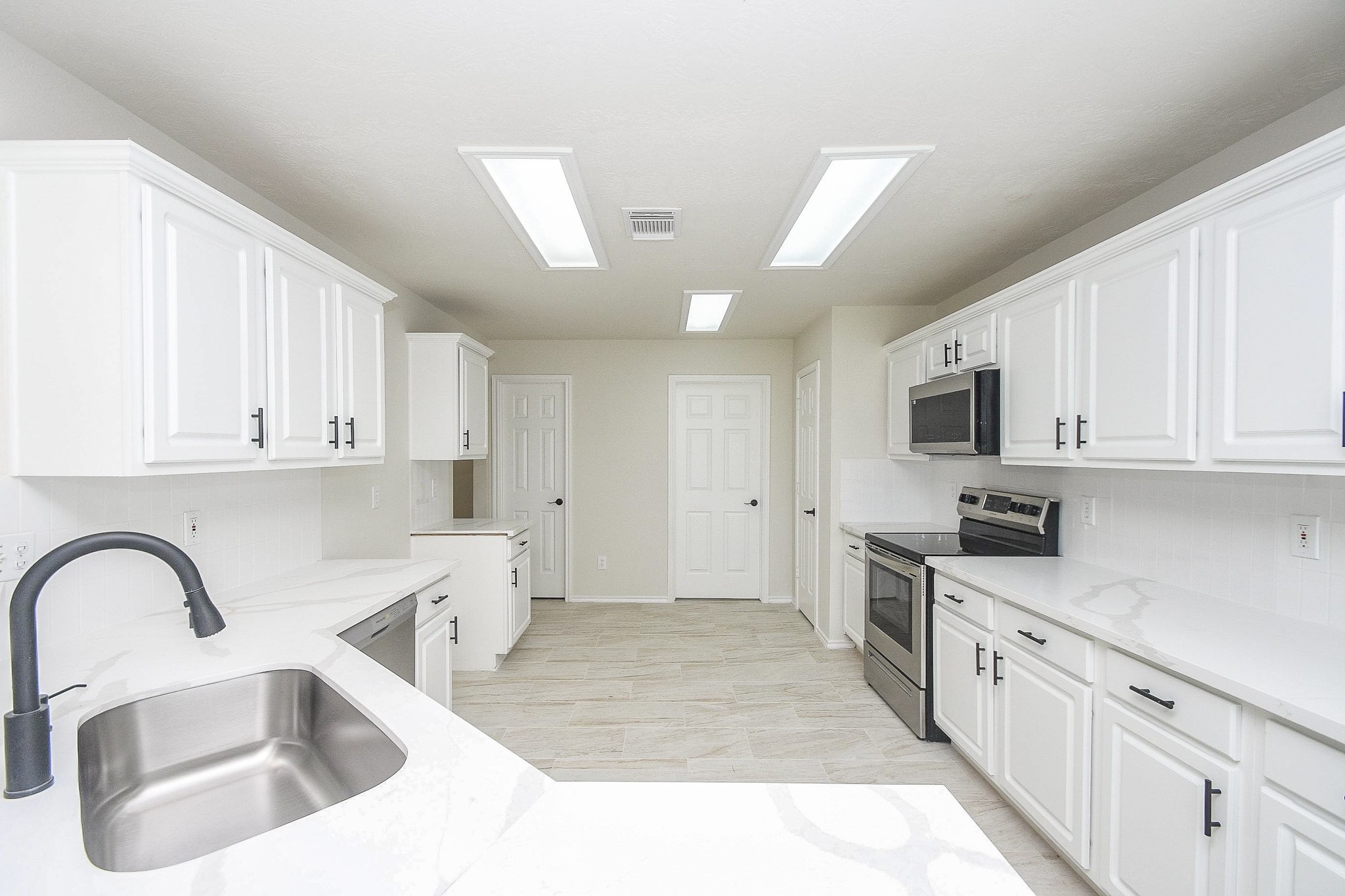 4810 Arbor Court Rosenberg, TX 77471 - Photo 7 of 20 a kitchen with stainless steel appliances granite countertop a sink a stove top oven a refrigerator with white cabinets and granite countertops