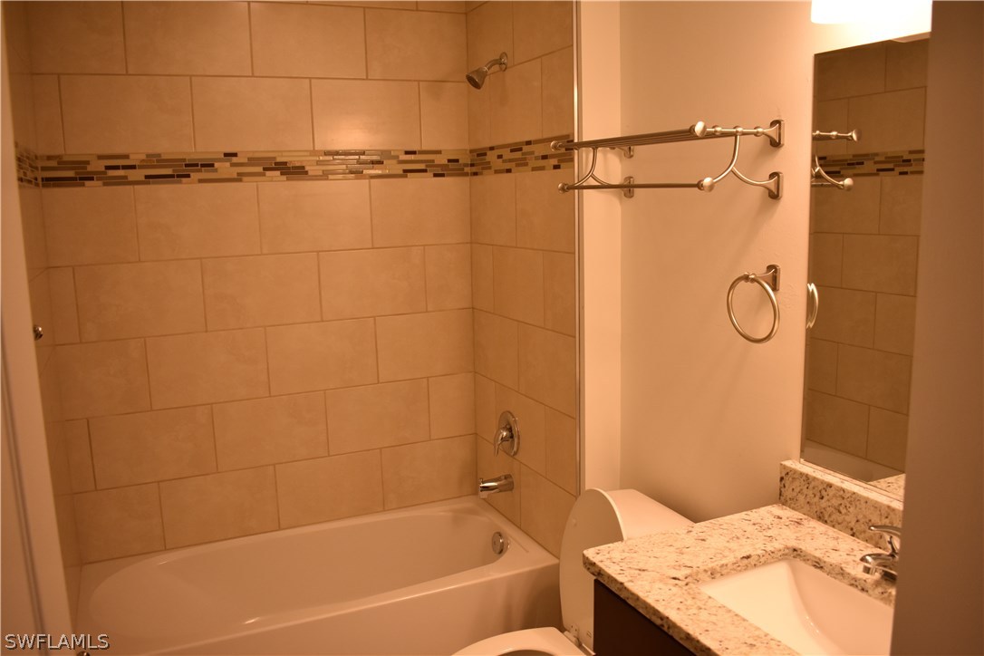 8152 Anhinga Road Fort Myers, FL 33967 - Photo 15 of 19 a bathroom with a granite countertop bathtub shower sink and vanity